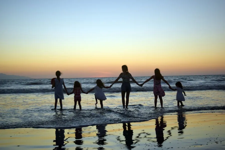 A family holding hands at the waterline at sunset